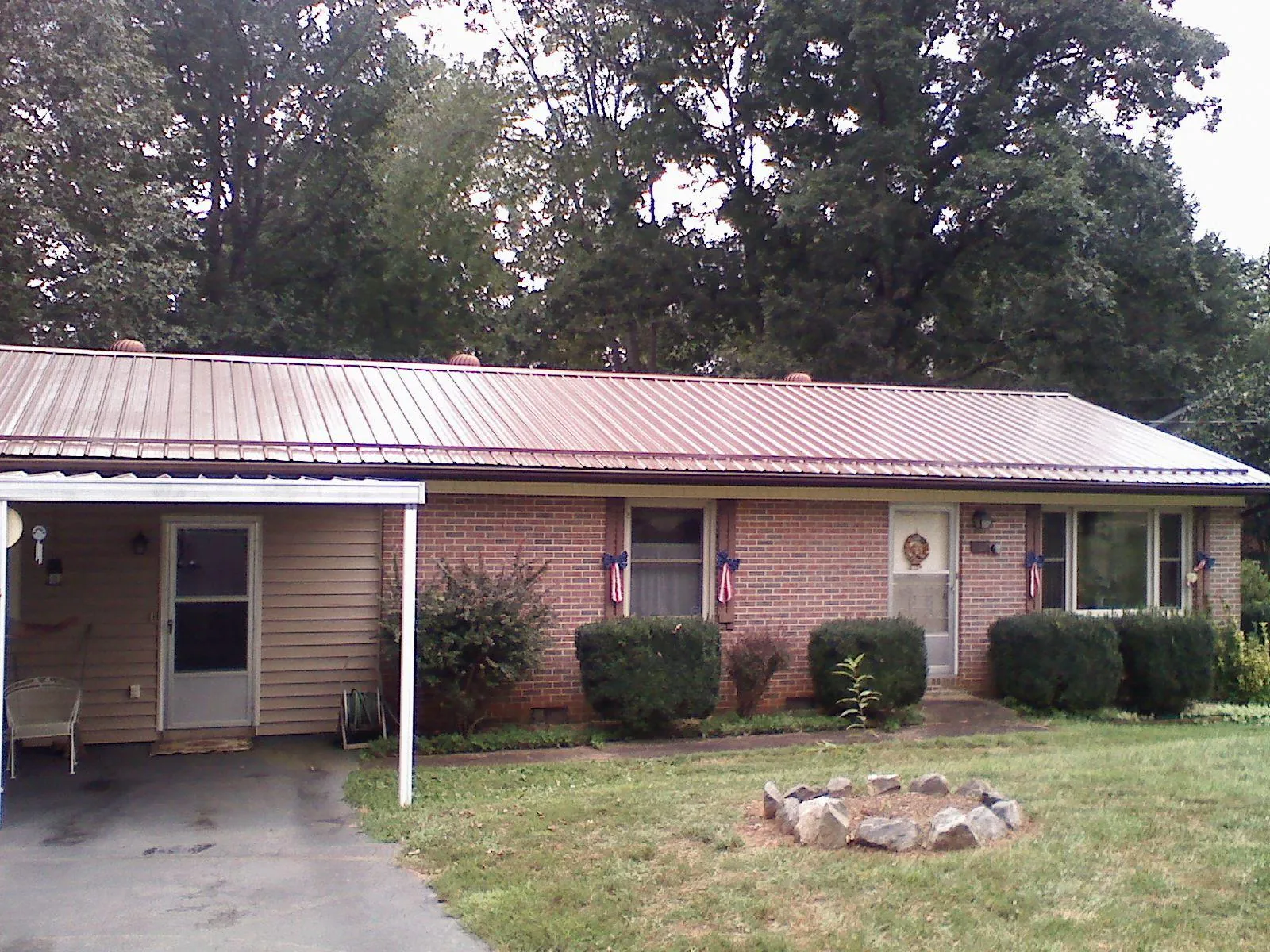 Bronze metal roof and carport on a brick ranch home — Roof Repair work by our crew in Carlock