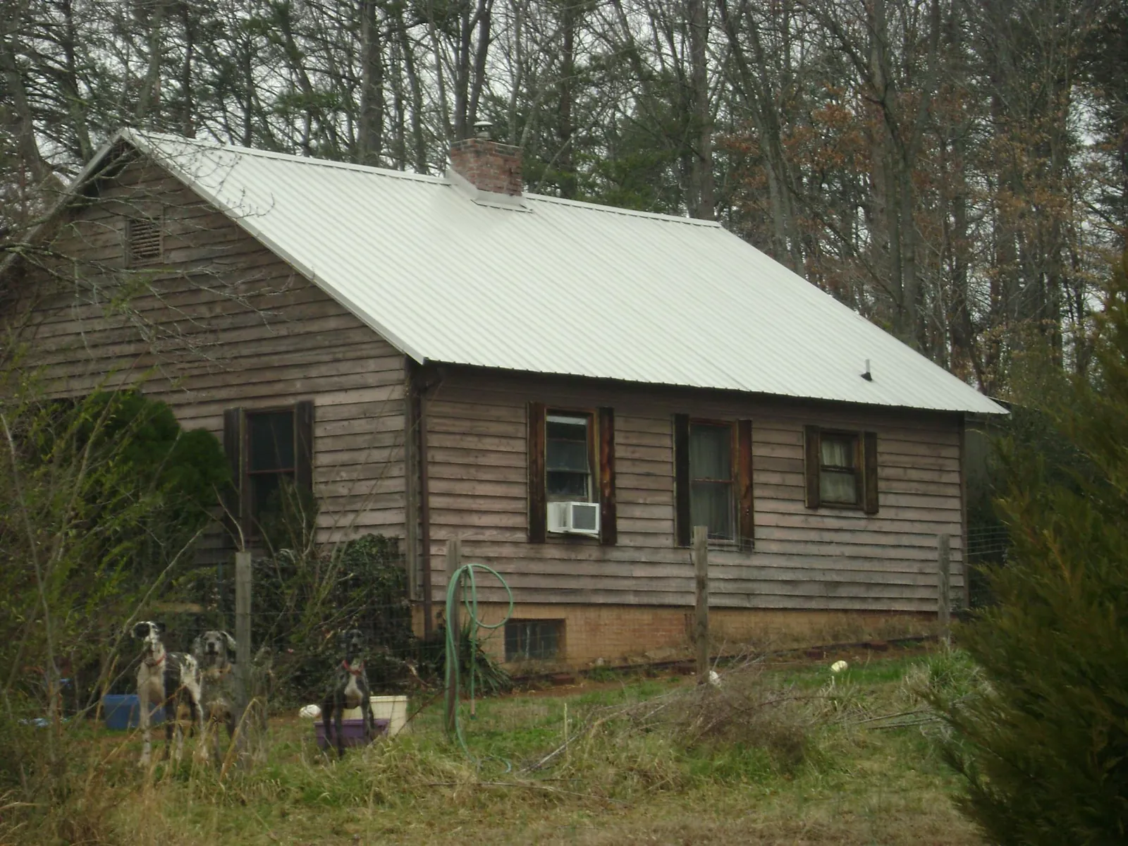 White metal roof on an old wood sided farmhouse, from a Metal Roof Installation job in Carlock